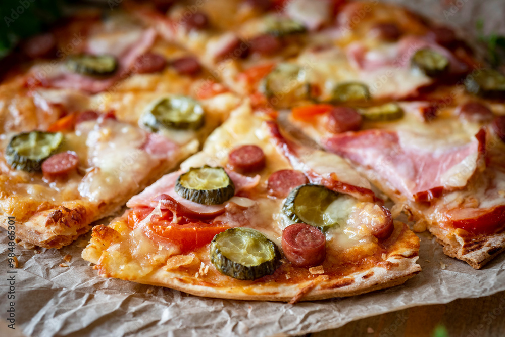 Italian pizza with bacon, pickles, tomato sauce, tomatoes and mozzarella. Close-up Italian pizza with bacon, pickles, tomato sauce, tomatoes and mozzarella. Close-up