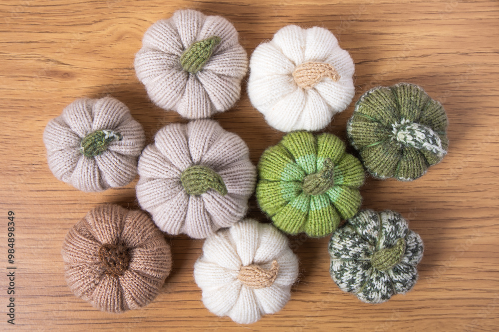 Knitted white, green and beige pumpkins on brown wooden background with place for text. Concept of autumn, Halloween, Thanksgiving. Handmade work. Flat lay, copy space Knitted white, green and beige pumpkins on brown wooden background with place for text. Concept of autumn, Halloween, Thanksgiving. Handmade work. Flat lay, copy space