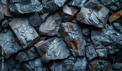 A pile of rocks with a dark grey color. The rocks are rough and jagged. Concept of ruggedness and toughness photo