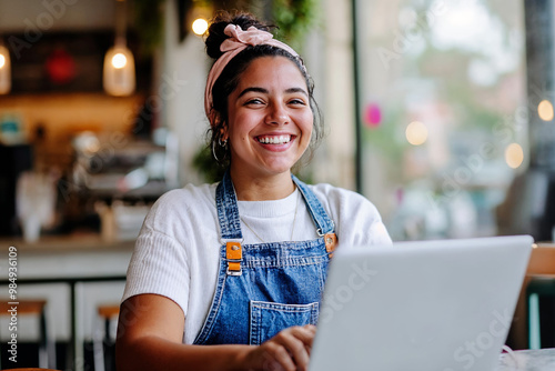 Female woman hispanic Shop owner, small business cafe. Working on a laptop computer, Running work, boss, manager. Student phd study.  photo