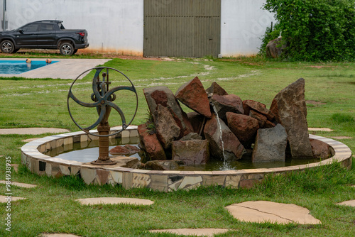 Beautiful stone fountain with water pump next to it photographed on a farm in the Campim Rasteiro neighborhood, municipality of Contagem, Minas Gerais photo