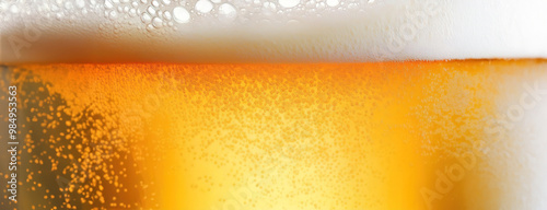 Obraz na płótnie Close-up of a glass of beer with foam and bubbles, showing condensation. Panorama with copy space. w salonie