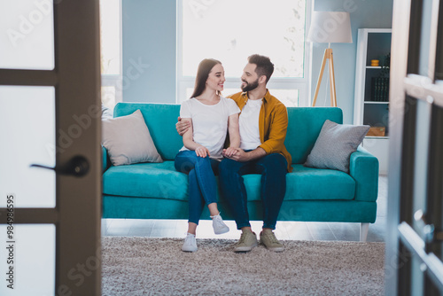 Full size photo of two young partners sit couch hold arms free time modern interior apartment indoors