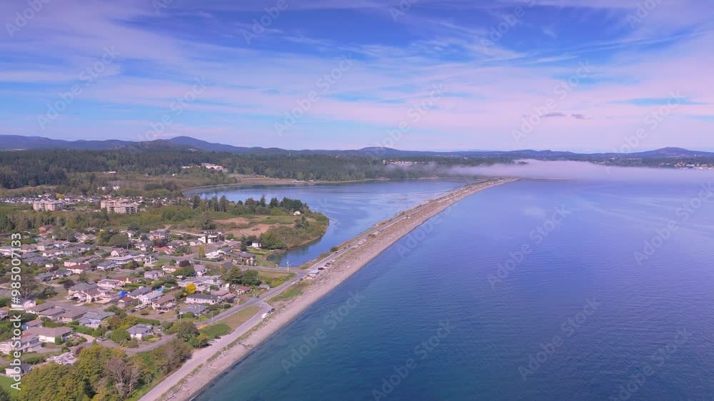 Aerial view of a coastal town with a long sandy beach and a calm blue ocean Aerial view of a coastal town with a long sandy beach and a calm blue ocean