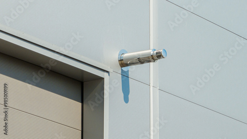 Stainless steel ventilation chimney on the wall of a new warehouse or factory. 