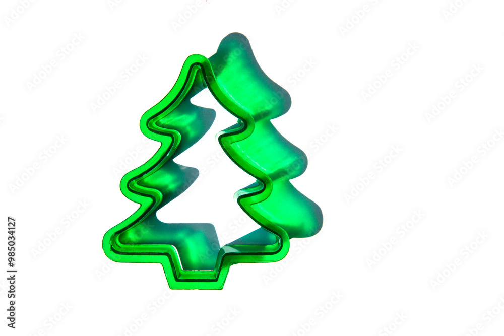 flat lay close-up of a green Christmas tree cookie cutter against a white background with copy space available flat lay close-up of a green Christmas tree cookie cutter against a white background with copy space available