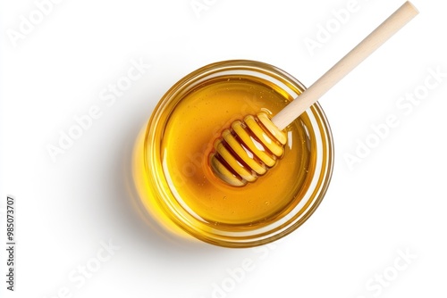 Flat lay glass bowl of honey with dipper on white background.