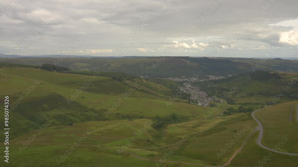 Camera panning over green valley with winding road Camera panning over green valley with winding road