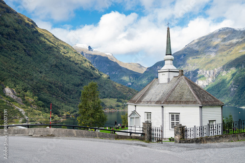 view of the beautiful bay of geiranger fjord in norway with mountains rocks and an old temple church