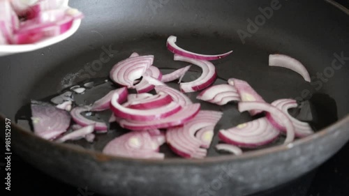 Pouring red onions in pan photo