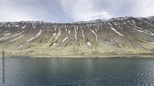 Isafjordur, Iceland - sail away alongside partially snow covered hills on scenic cruise out of fjord parallel to Djúpvegur street 61 photo