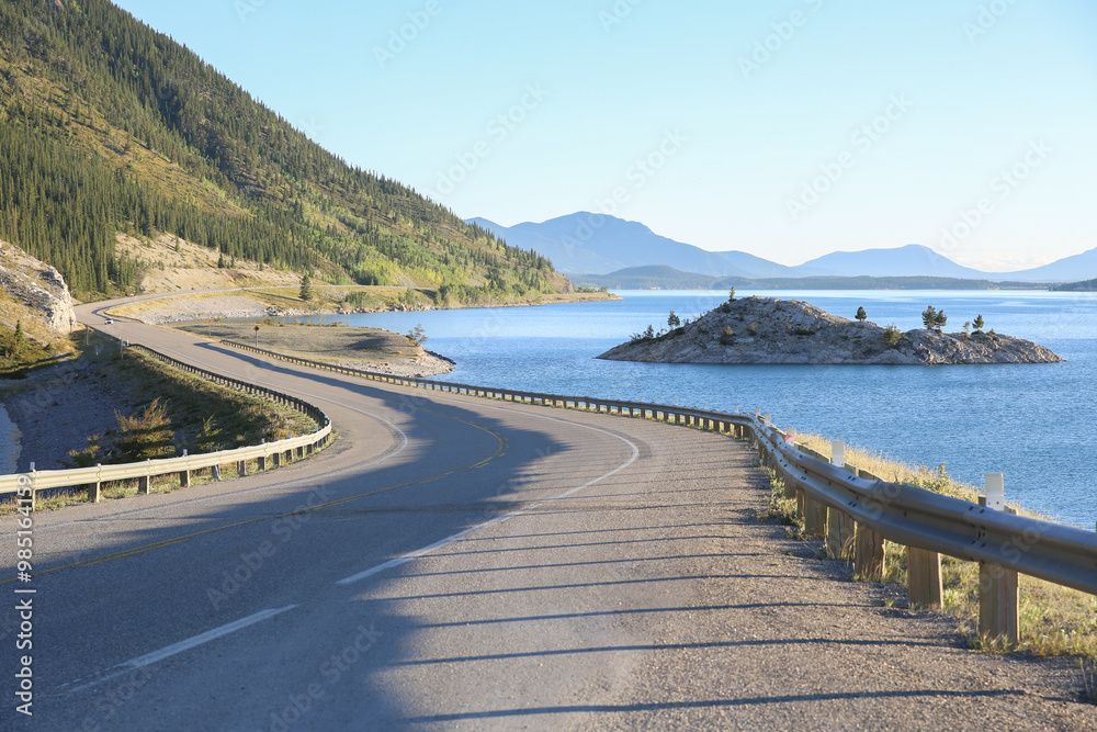 Paved winding highway through the mountains beside a lake Paved winding highway through the mountains beside a lake