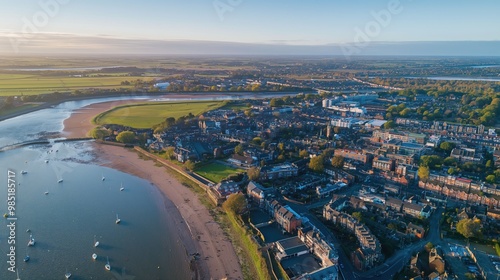 Aerial drone of Colchester Hythe in Essex, England. River Colne waterfront, buildings, streets. Seaweed-covered riverbank, tree-lined streets, sunset over buildings. Famous landmark in Britain,