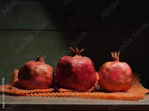 Red organic grown pomegranates in bright sunlight with copyspace. Natural fruit concept image.