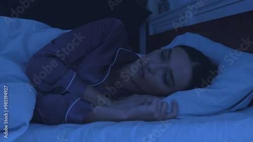 Sleep disorder. Young girl tossing and turning in bed, can't sleep