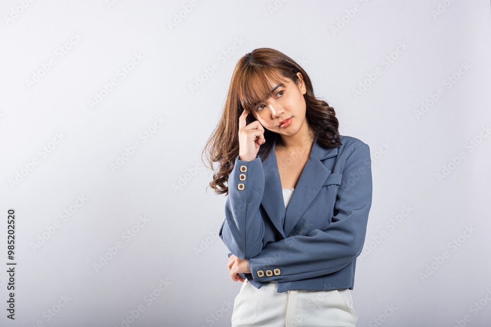 Portrait of an Asian business woman deep in thought thinking chin in her finger, pondering a question. Studio shot on white background with ample copy space, portraying her contemplative expression Portrait of an Asian business woman deep in thought thinking chin in her finger, pondering a question. Studio shot on white background with ample copy space, portraying her contemplative expression