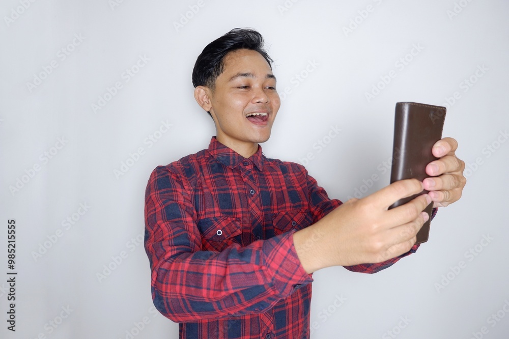 portrait of a handsome Indonesian man having a random expression wearing a checkered red flannel shirt on a white isolated background portrait of a handsome Indonesian man having a random expression wearing a checkered red flannel shirt on a white isolated background