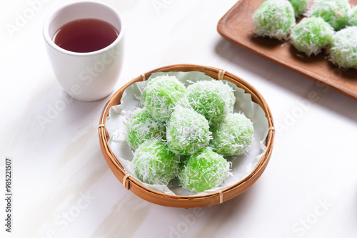 klepon or onde-onde made from glutinous rice flour and filled with brown sugar covered with grated coconut. Perfect for recipe, article, catalogue, commercial, or any cooking content. photo