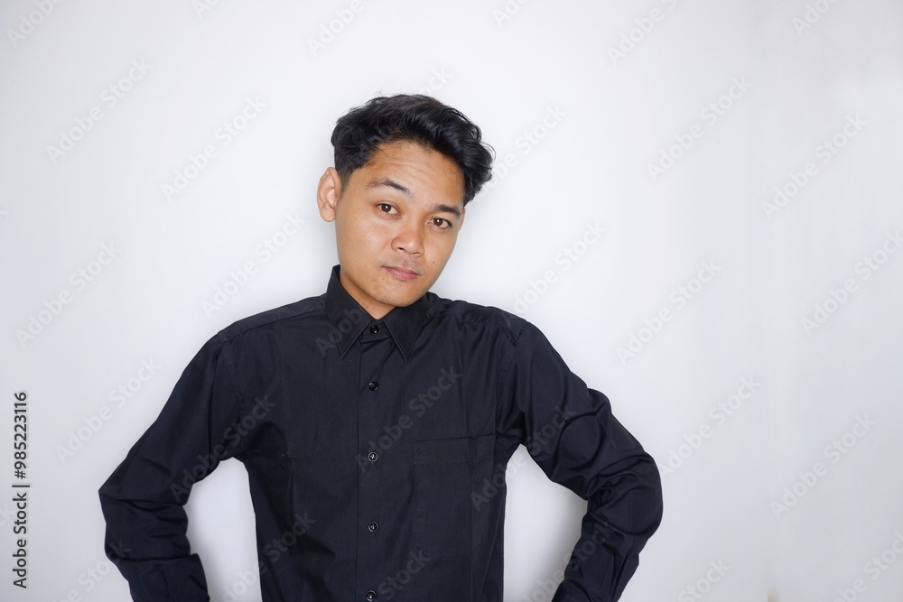 Portrait of a handsome Indonesian man wearing a plain black shirt with a random pose isolated on a white background