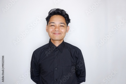 Photos Portrait of a handsome Indonesian man wearing a plain black shirt with a random