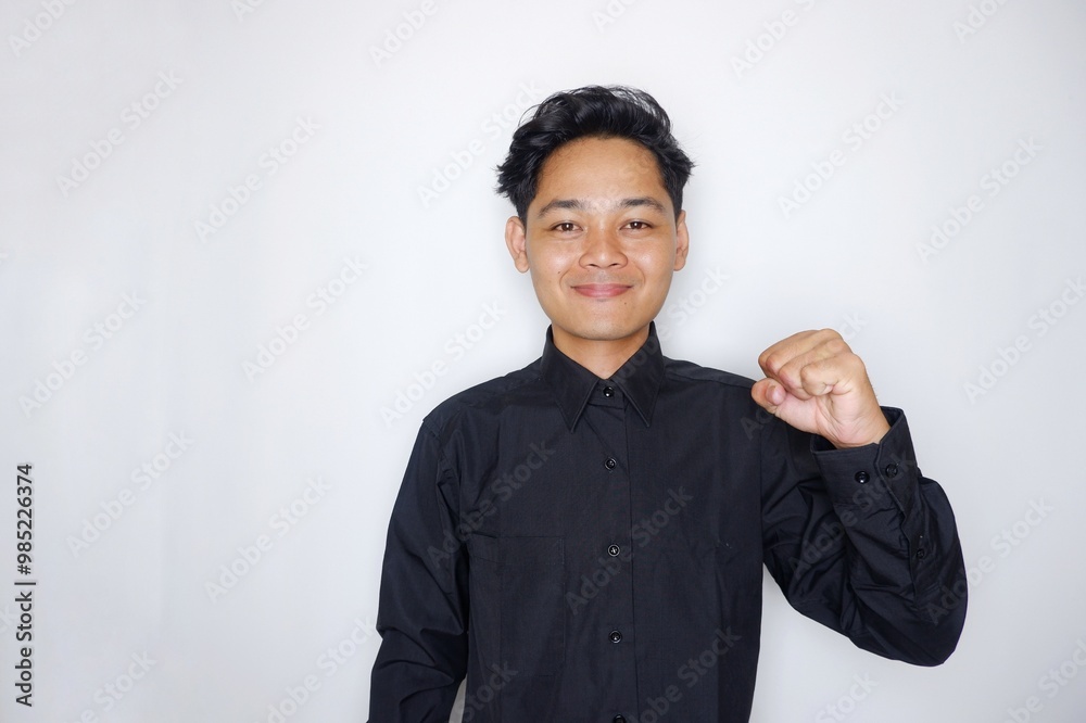 Portrait of a handsome Indonesian man wearing a plain black shirt with a random pose isolated on a white background Portrait of a handsome Indonesian man wearing a plain black shirt with a random pose isolated on a white background