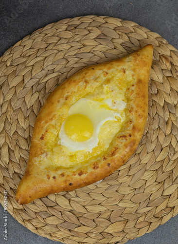 Fototapeta Naklejka Na Ścianę i Meble -  khachapuri adjara traditional Georgian cuisine meal. Baked bread with cheese and egg filling. National pastry snack. Free space concept