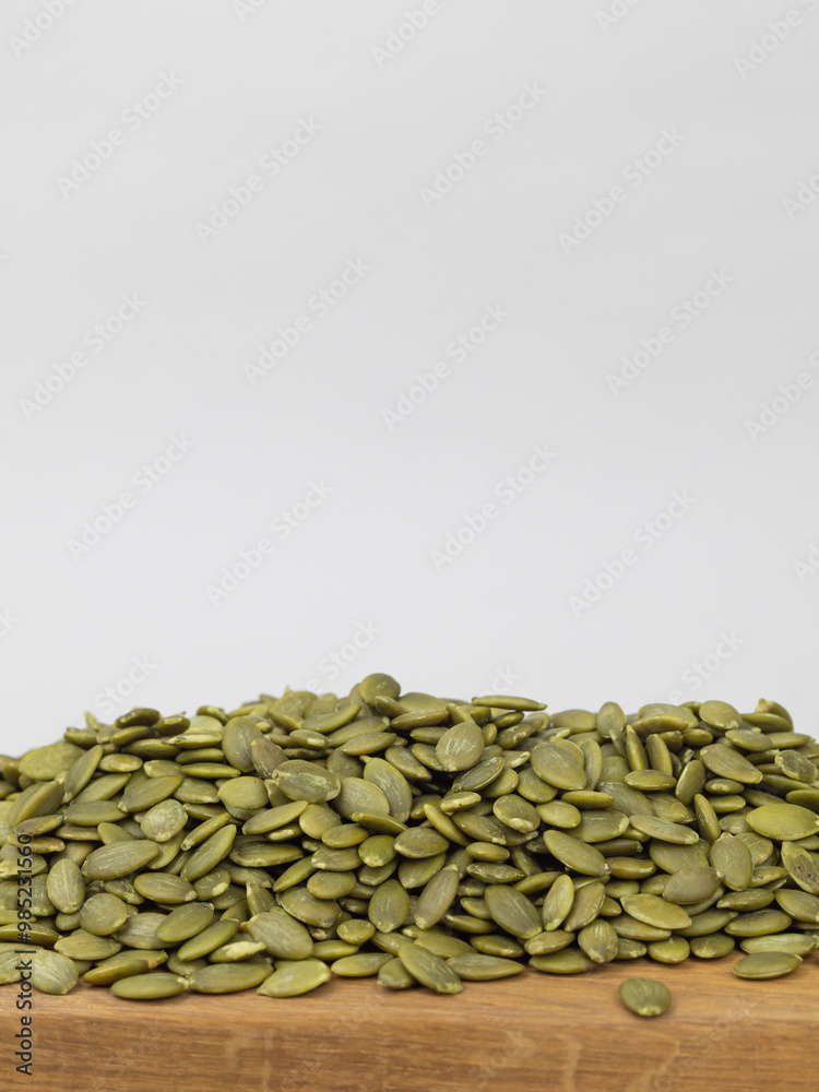 Pumpkin seeds on a wooden board, space for text Pumpkin seeds on a wooden board, space for text