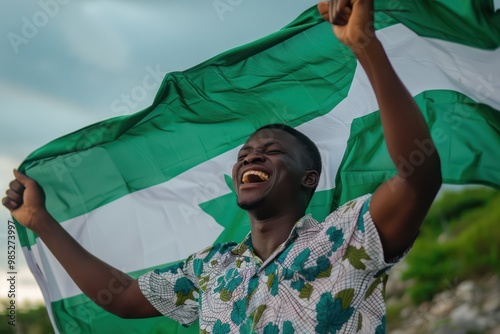 Nigerian flag bearer proudly holds aloft national emblem amidst lush green plants, beaming joy, pride in high-resolution medium shot. His smile radiates warmth as he gazes directly into camera lens. photo