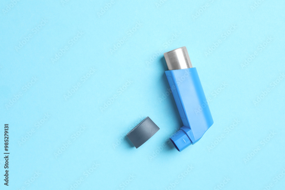Asthma inhaler on light blue background, top view. Space for text Asthma inhaler on light blue background, top view. Space for text
