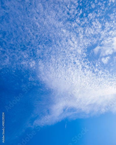 The bright blue sky with white clouds in the sunny day.