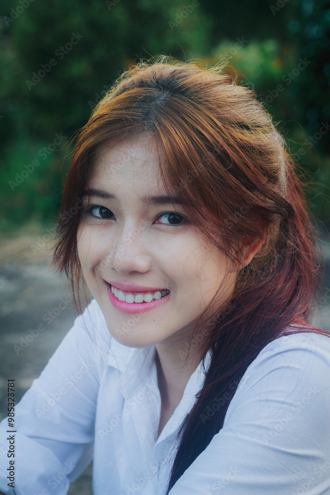 A portrait of a smiling woman enjoying a beautiful summer day outdoors in a park. A portrait of a smiling woman enjoying a beautiful summer day outdoors in a park.