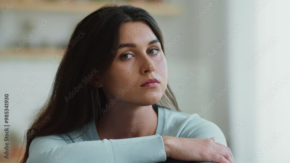 Seasonal depression. Young sad woman looking away, then turning to camera and looking seriously, suffering from mood swings at home, close up Seasonal depression. Young sad woman looking away, then turning to camera and looking seriously, suffering from mood swings at home, close up