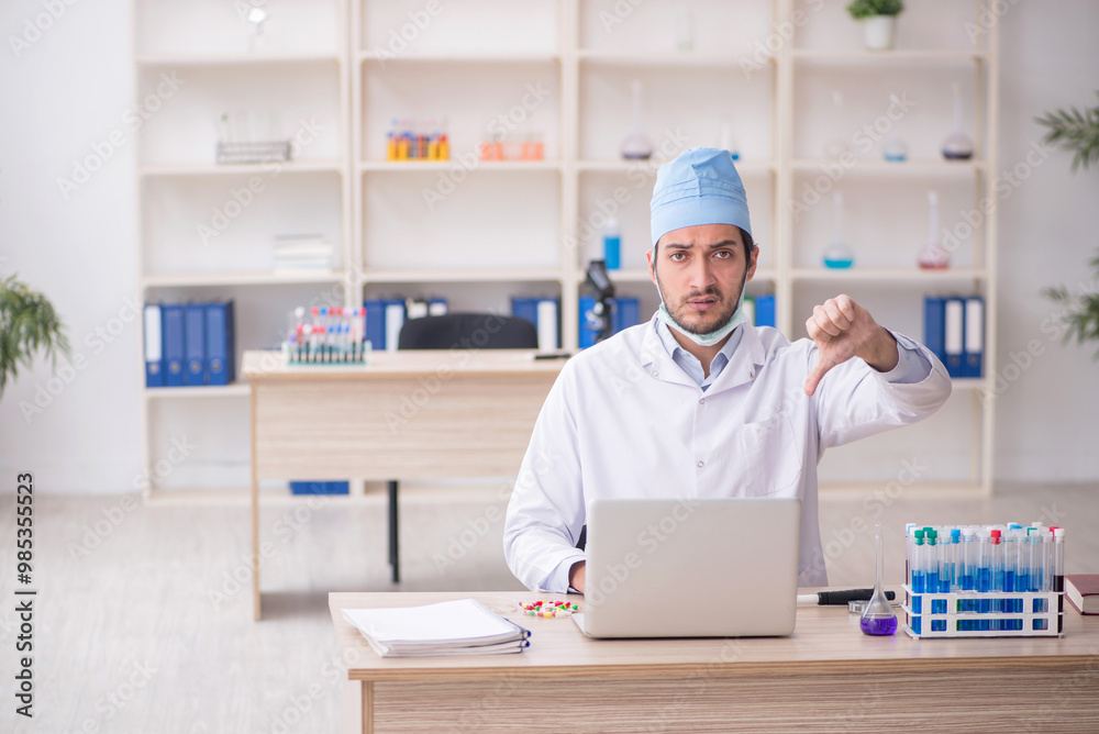 Young male chemist working at the lab Young male chemist working at the lab