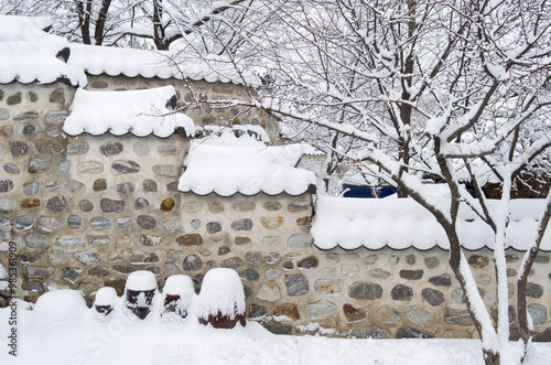 Jung-gu, Seoul, South Korea - February 4, 2013: Snow covered roof tile and crocks(Jangdok) at Namsangol Hanok Village photo