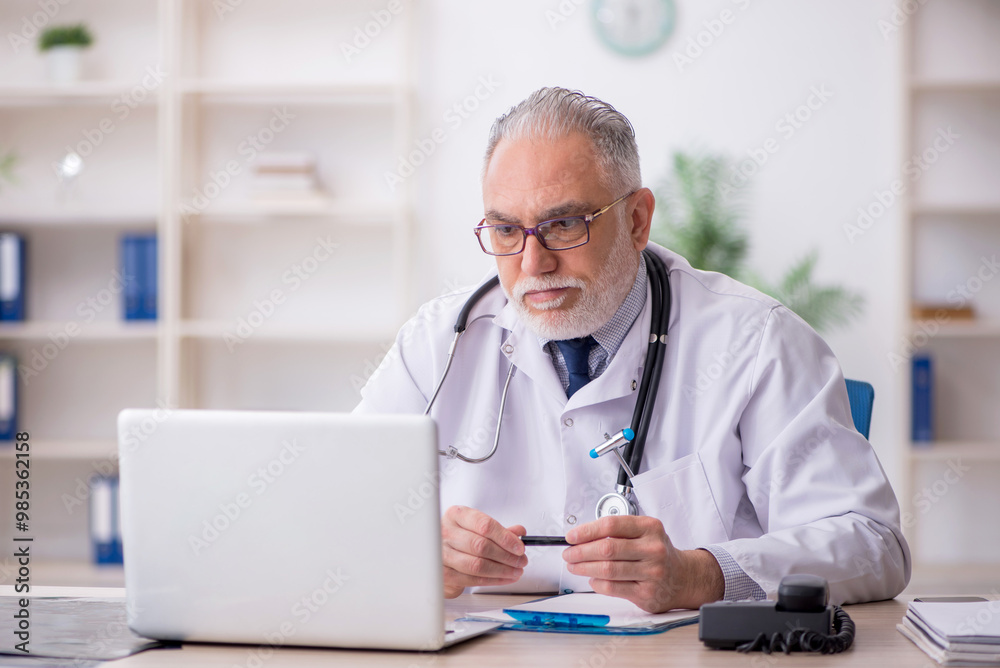 Old male doctor in telemedicine concept Old male doctor in telemedicine concept