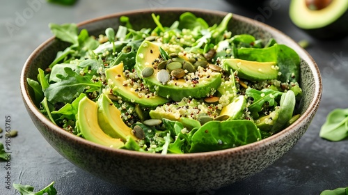 Leafy green salad with avocado, seeds, and quinoa in a bowl