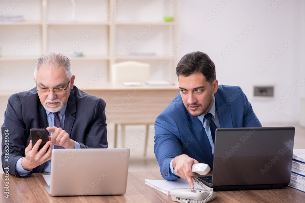 Two male employees working in the office Two male employees working in the office