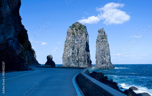 Cliffs and a curved road with the background of Samseonam Rocks on the sea near Ulleung-gun, South Korea photo