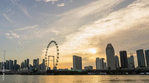 Singapore - August 27, 2023 : Time lapse Day to Night view of downtown district Singapore. Timelapse view of Marina Bay with blue sky and cloud moving at day with its illuminated skyscrapers.