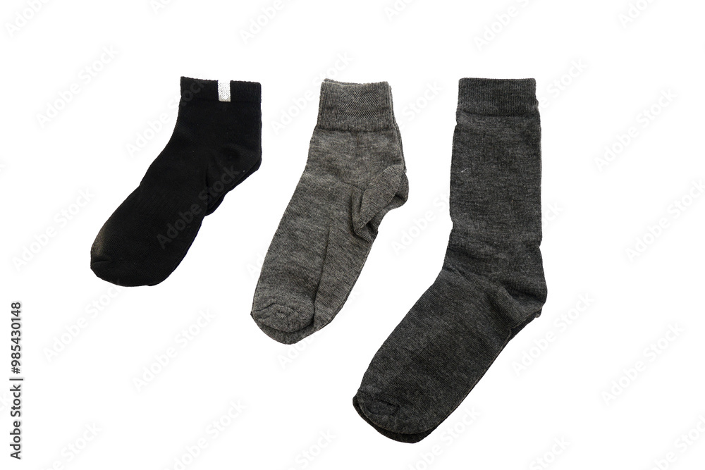 Three pairs of socks, one black and two gray, laid out on a white background. Socks are arranged in order of size from small to large Three pairs of socks, one black and two gray, laid out on a white background. Socks are arranged in order of size from small to large