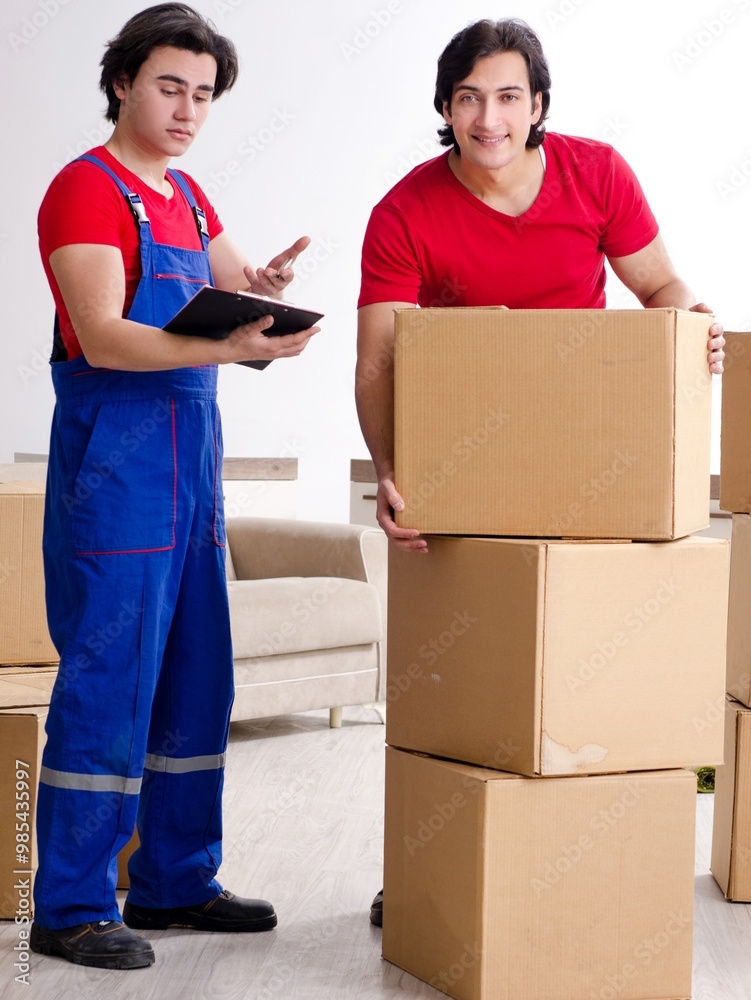 Two young contractor employees moving personal belongings
