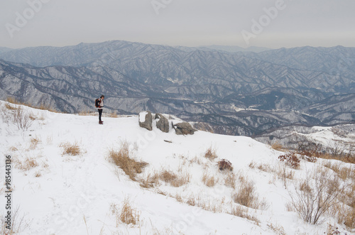 Pocheon-si, Gyeonggi-do, South Korea - January 4, 2013: A female hiker is taking a rest on the snow covered Myeongseongsan Mountain photo