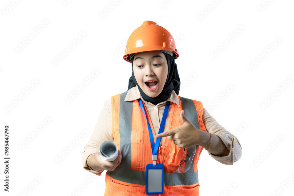 young Asian female construction worker in hijab stands pointing to a roll of blueprints she is carrying, industrial and construction concepts, isolated against a white background. young Asian female construction worker in hijab stands pointing to a roll of blueprints she is carrying, industrial and construction concepts, isolated against a white background.