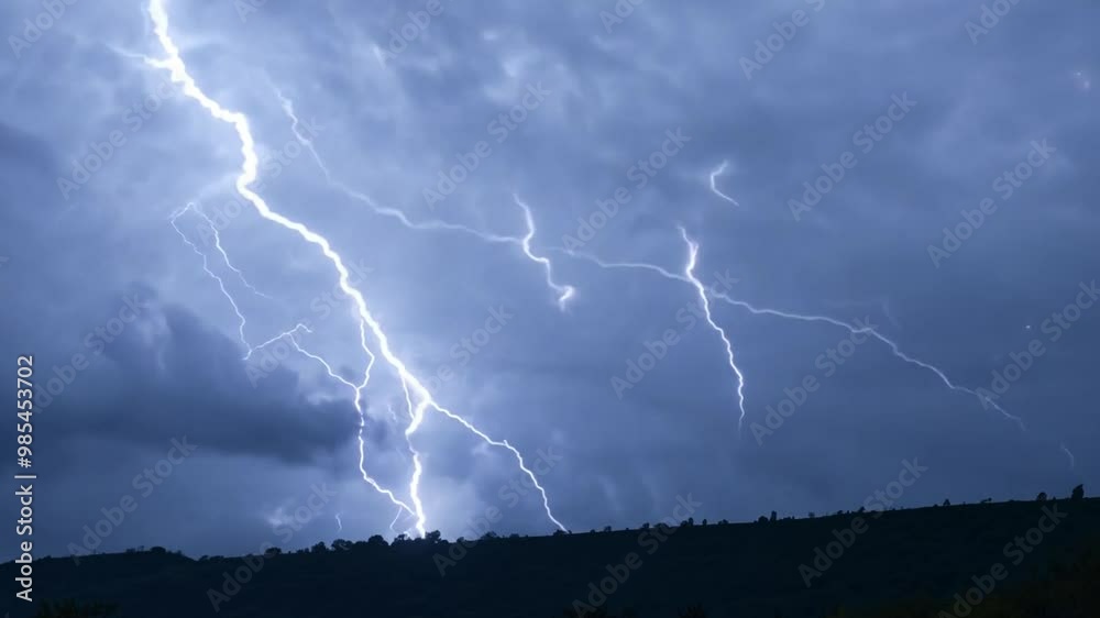 Stunning footage of the lightning striking over a dense forest during a thunderstorm