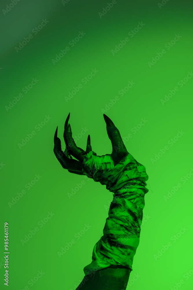 A bloodied witch hand wrapped in bandages, set against a green fire background. This demonic hand blends elements of vampires,aliens, and ghosts, evoking a spooky, monstrous feel perfect Halloween