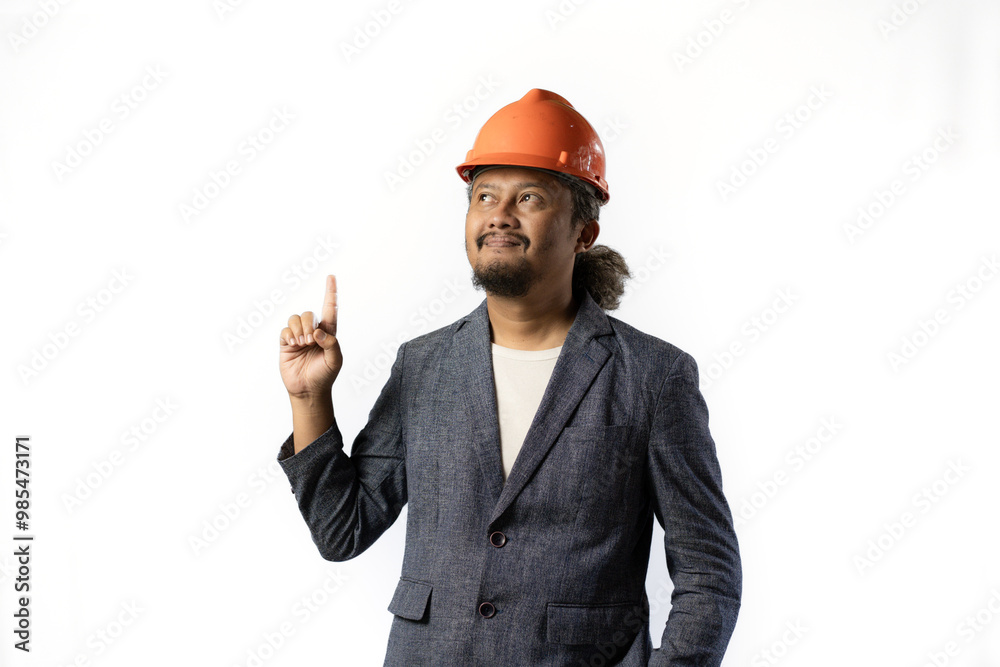 the project leader looks happy and holds up a finger. stylish asian man with orange suit and helmet on white background. construction or mining business concept photo the project leader looks happy and holds up a finger. stylish asian man with orange suit and helmet on white background. construction or mining business concept photo