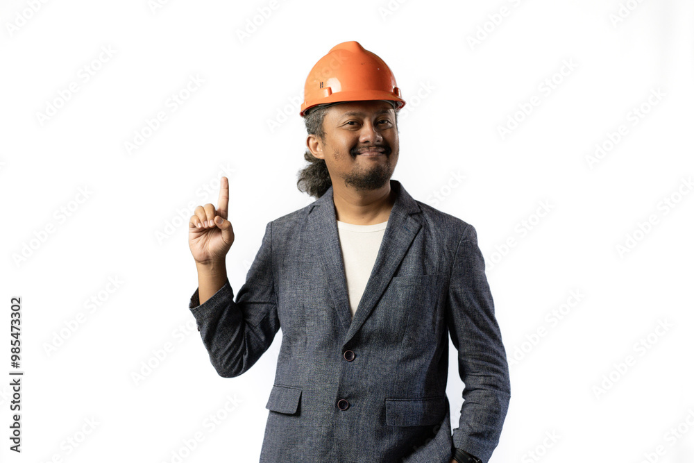 the project leader looks happy and holds up a finger. stylish asian man with orange suit and helmet on white background. construction or mining business concept photo the project leader looks happy and holds up a finger. stylish asian man with orange suit and helmet on white background. construction or mining business concept photo