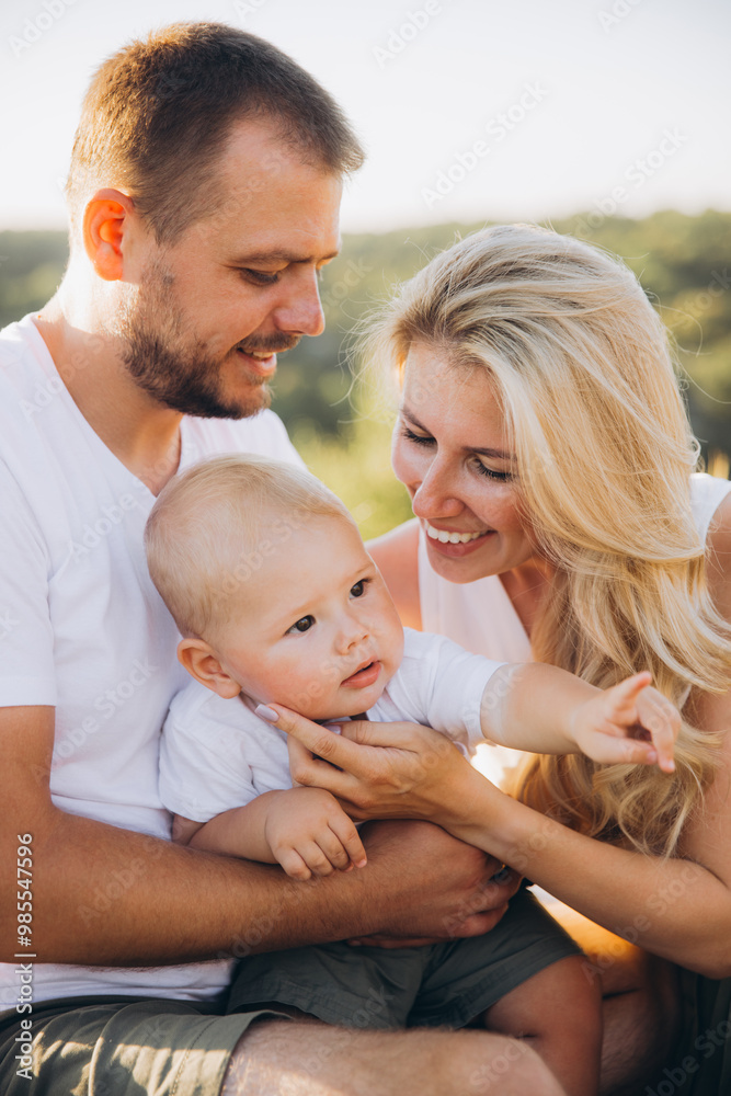 Happy Family Moment Outdoors with Parents and Baby Enjoying Sunny Day Together Happy Family Moment Outdoors with Parents and Baby Enjoying Sunny Day Together