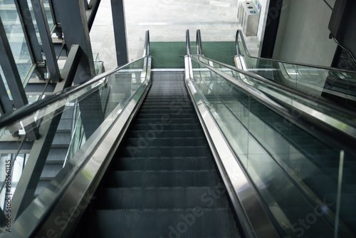 The escalator is empty and the stairs are black