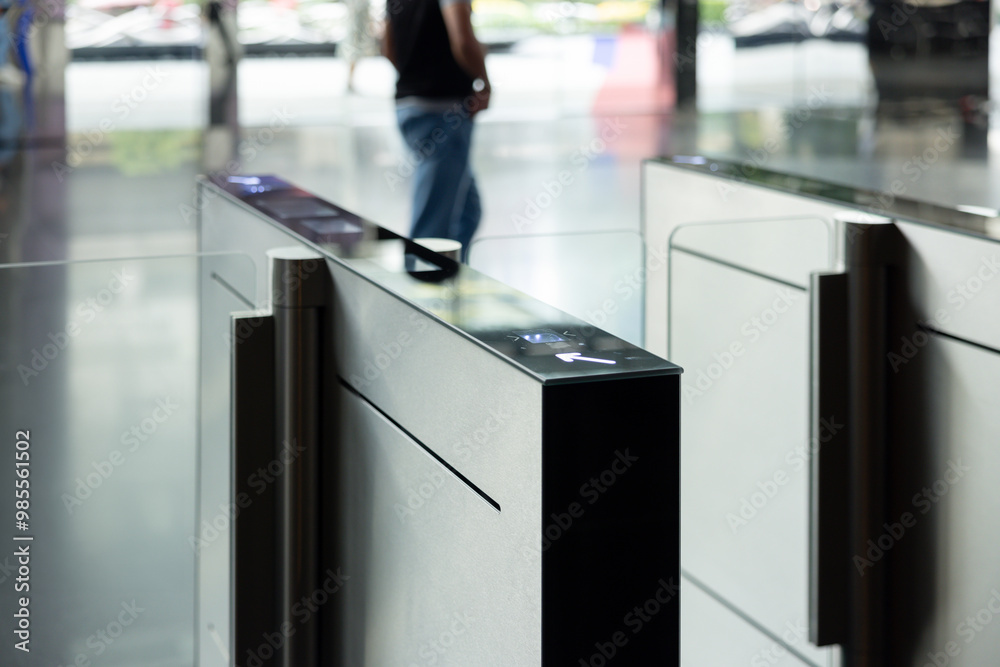 © Rattanachat - A man walks past a pair of electronic turnstiles. smart turnstiles. © Rattanachat - A man walks past a pair of electronic turnstiles. smart turnstiles.